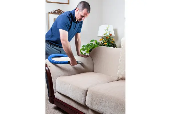 Homem usando produto caseiro para limpar sofá