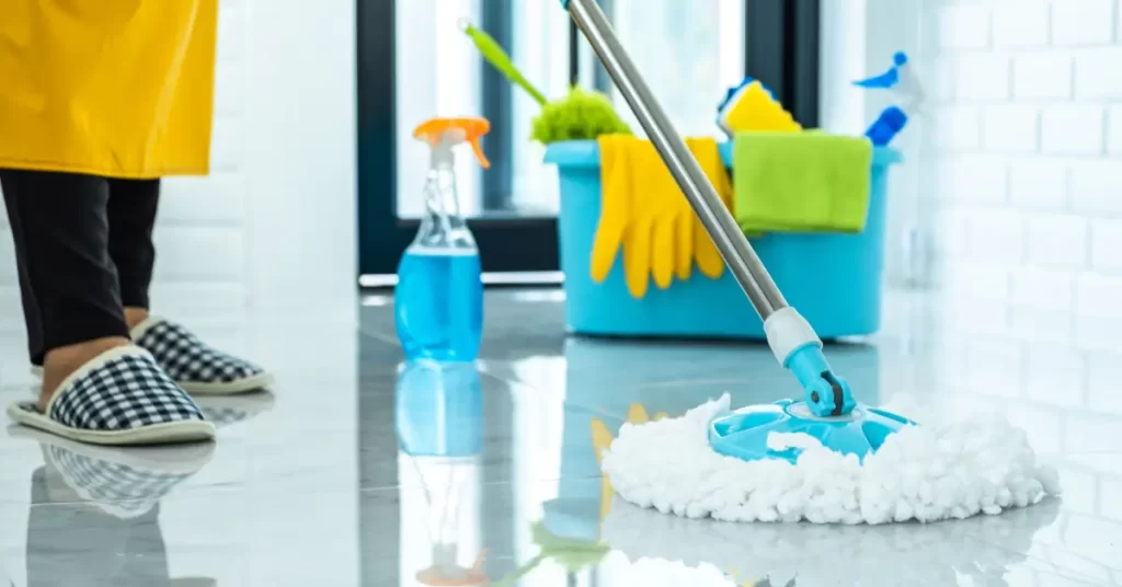 pessoa limpando o piso com mop e produtos de limpeza, mostrando o resultado após aplicar técnicas de como tirar cheiro de xixi de cachorro